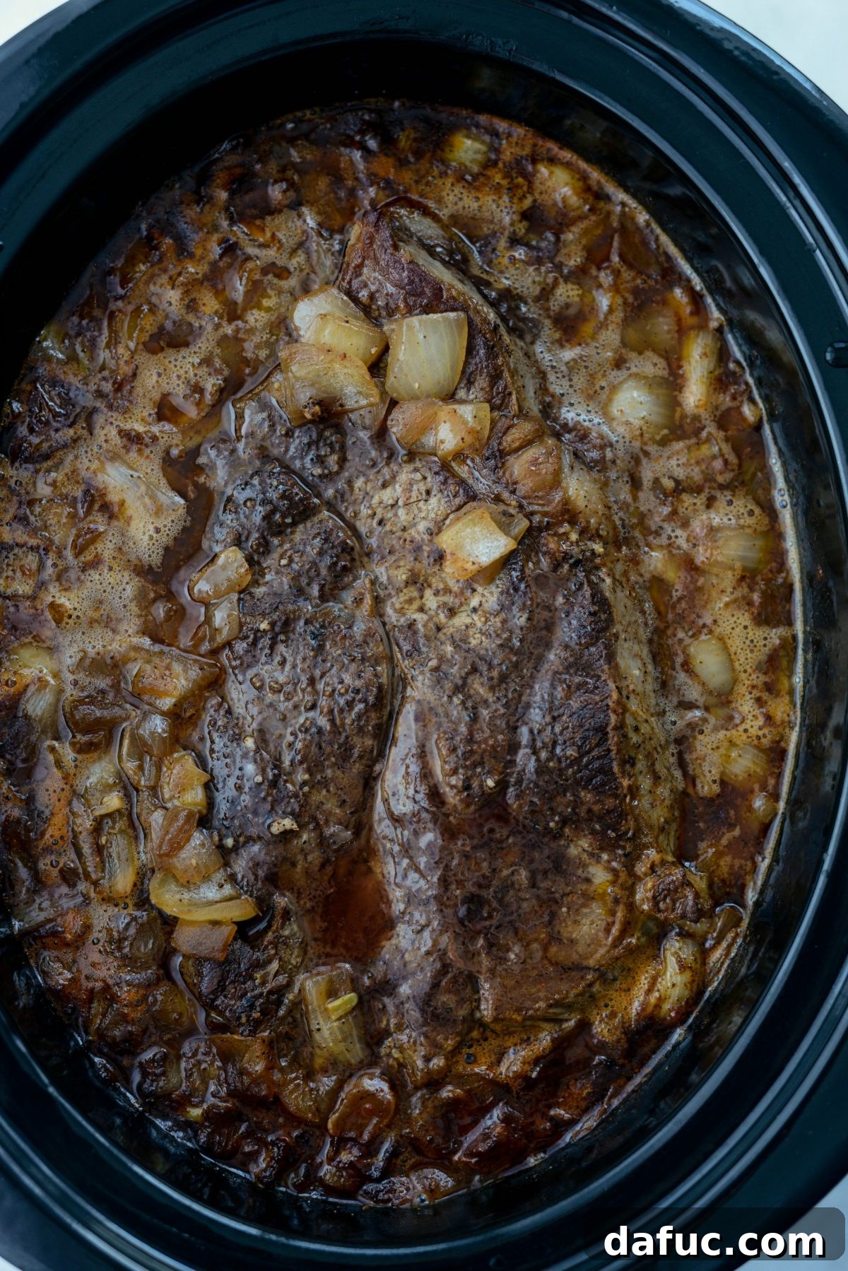 Fall-Apart Tender Slow Cooker Beef Barbacoa 14 A tender, perfectly cooked beef chuck roast after hours in the slow cooker, ready to be removed and shredded.