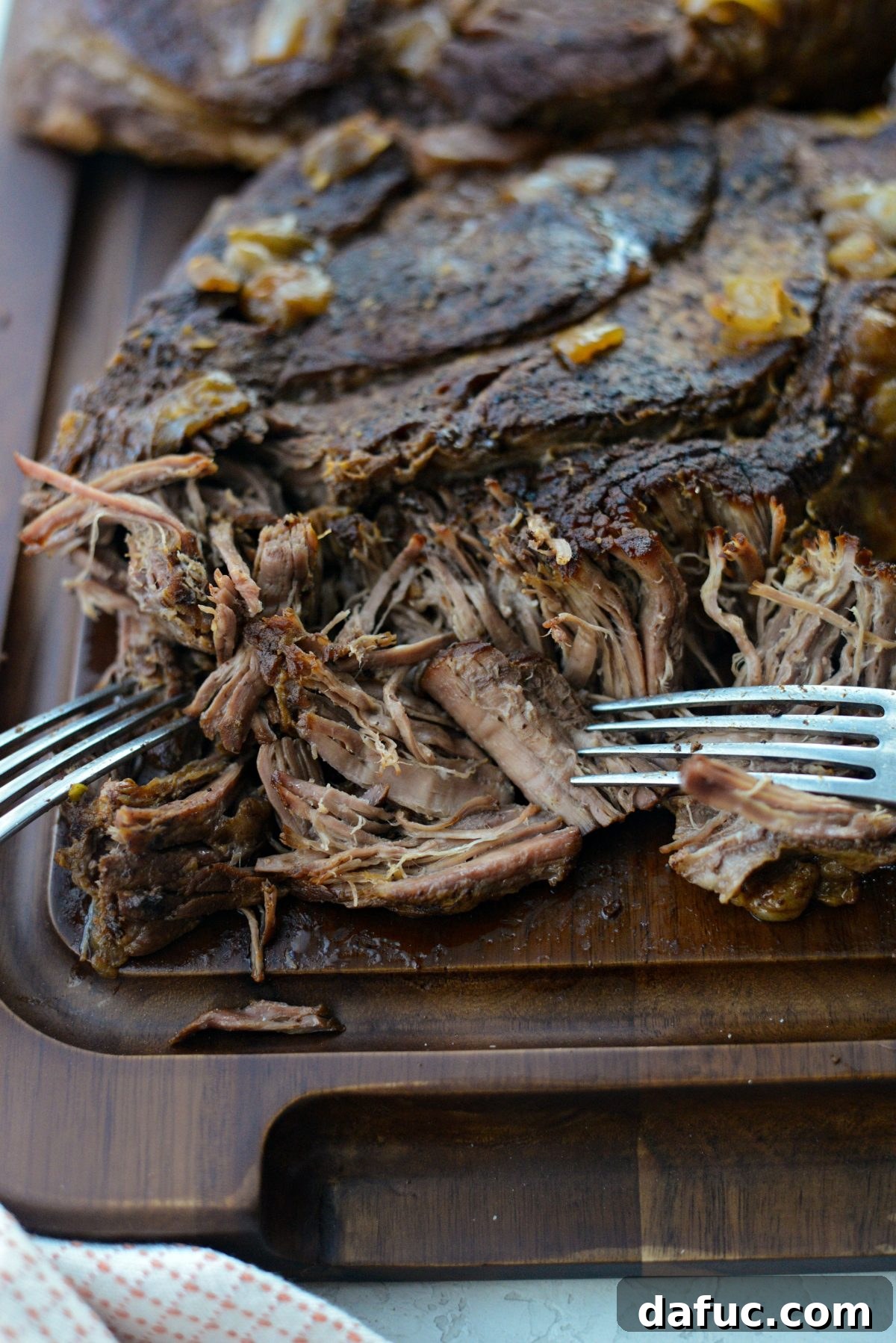 Fall-Apart Tender Slow Cooker Beef Barbacoa 15 Close-up of the tender beef being easily shredded into perfect strands with two forks.
