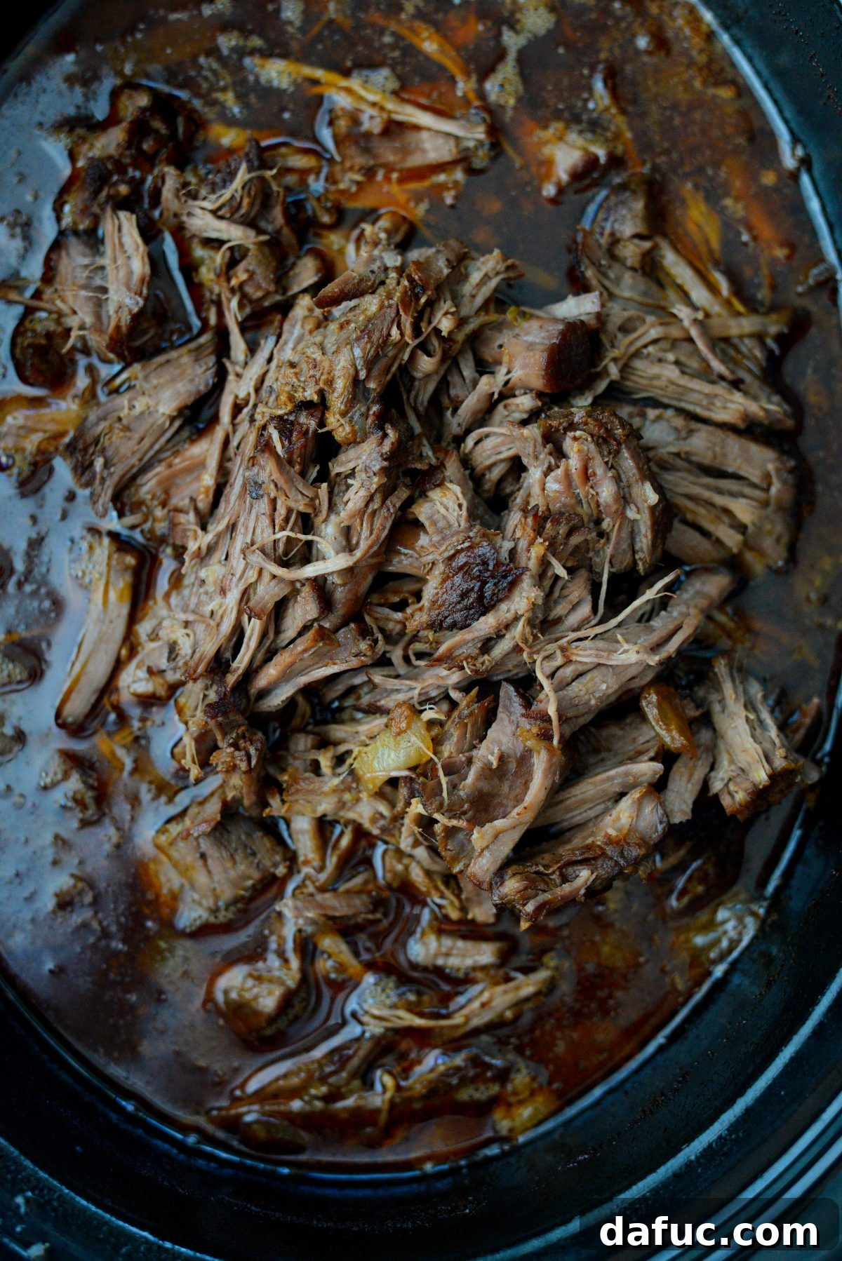 Fall-Apart Tender Slow Cooker Beef Barbacoa 17 The shredded beef barbacoa returned to the slow cooker, simmering in its delicious liquids for a final infusion of flavor.
