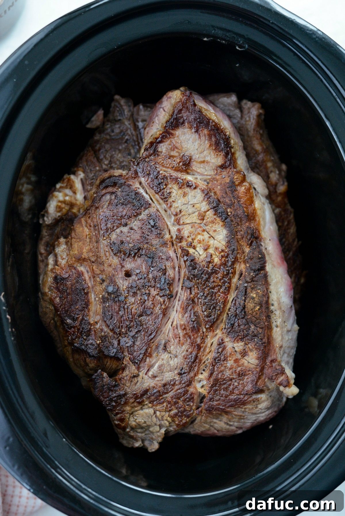 Fall-Apart Tender Slow Cooker Beef Barbacoa 7 The seared chuck roast comfortably settled in the slow cooker, ready for the next steps.