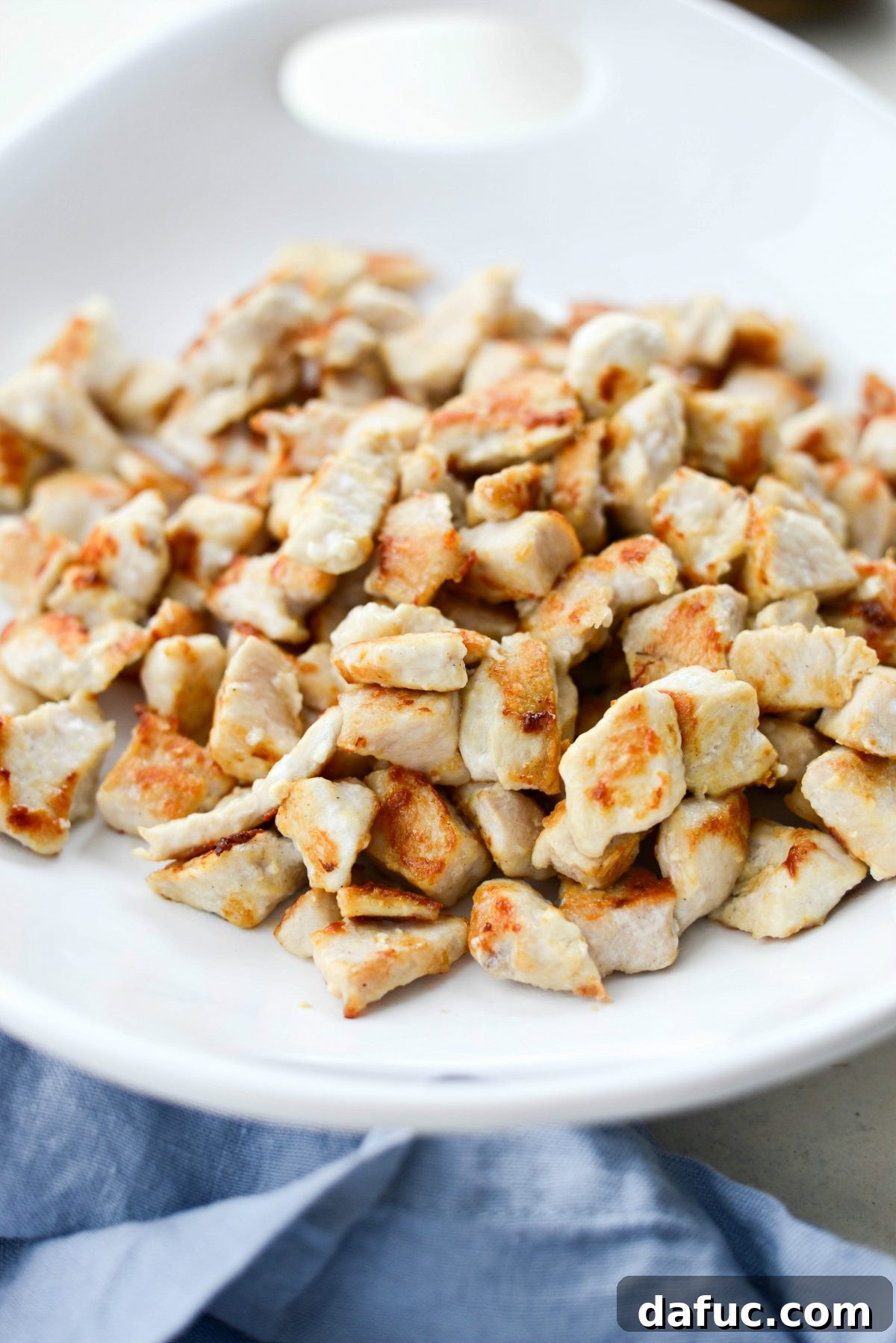 All crispy cooked chicken pieces transferred from the wok to a clean dish, ready to be added back later.