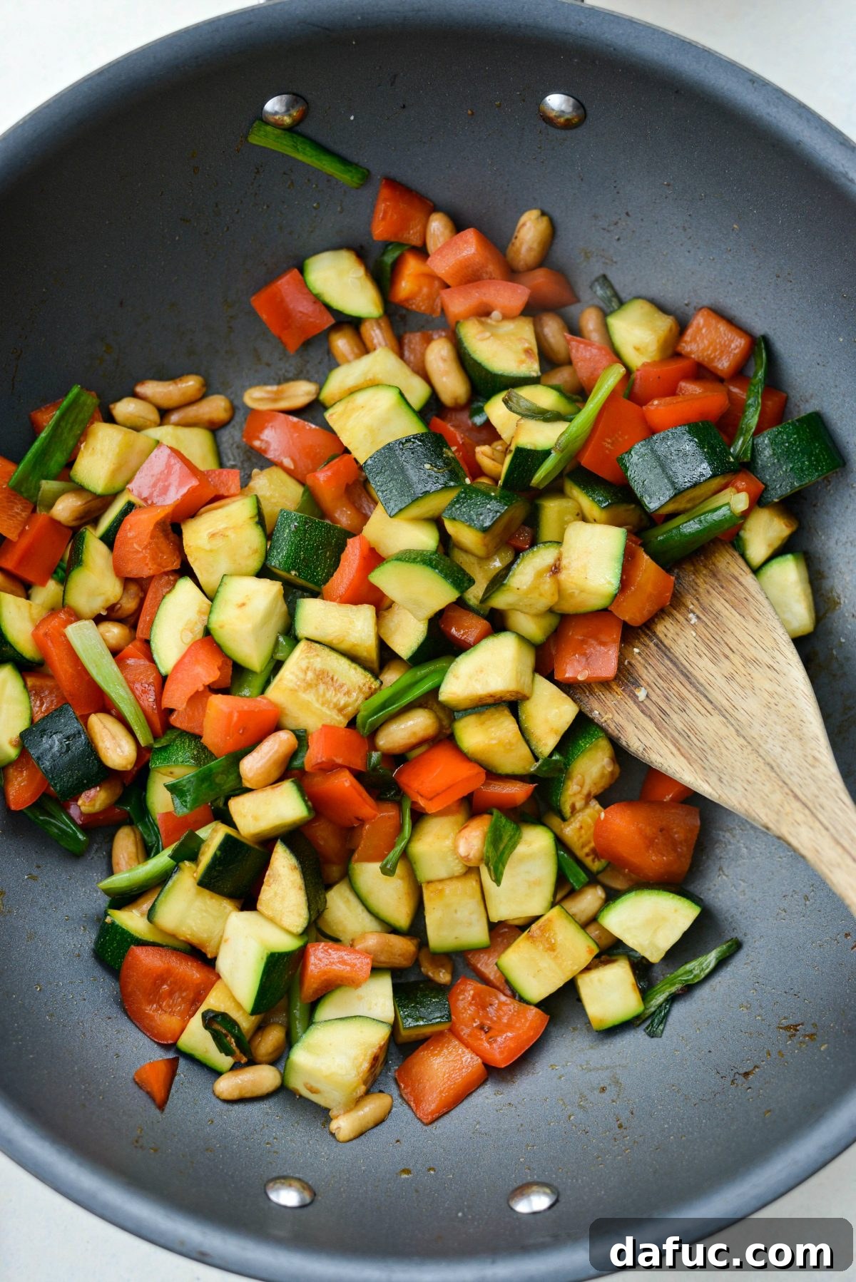 Cooked vegetables in a wok, showing some caramelization, ready for the sauce.
