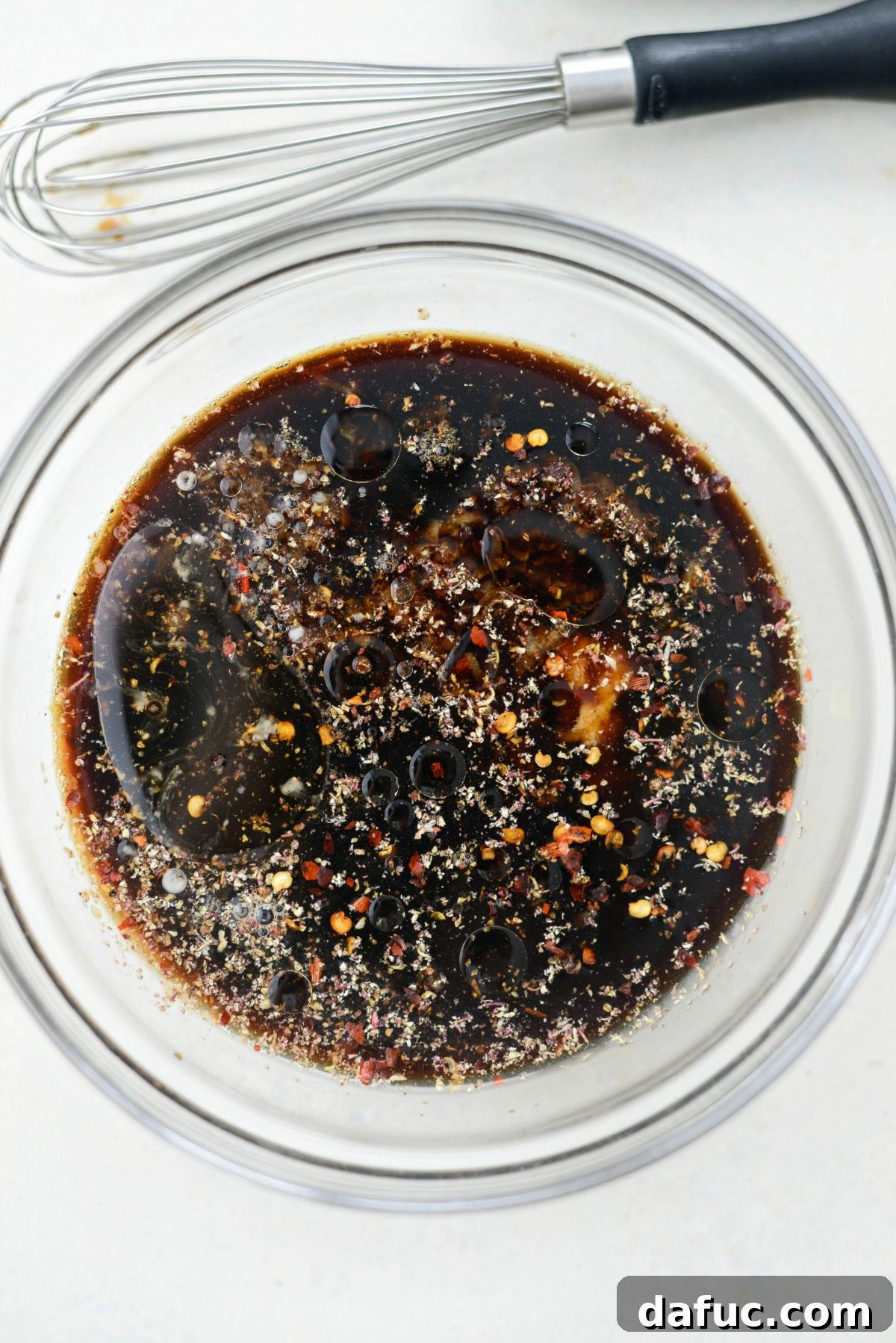 All the dry and wet ingredients for the Kung Pao sauce gathered in a single glass bowl, ready to be mixed, demonstrating the completeness of the preparation.