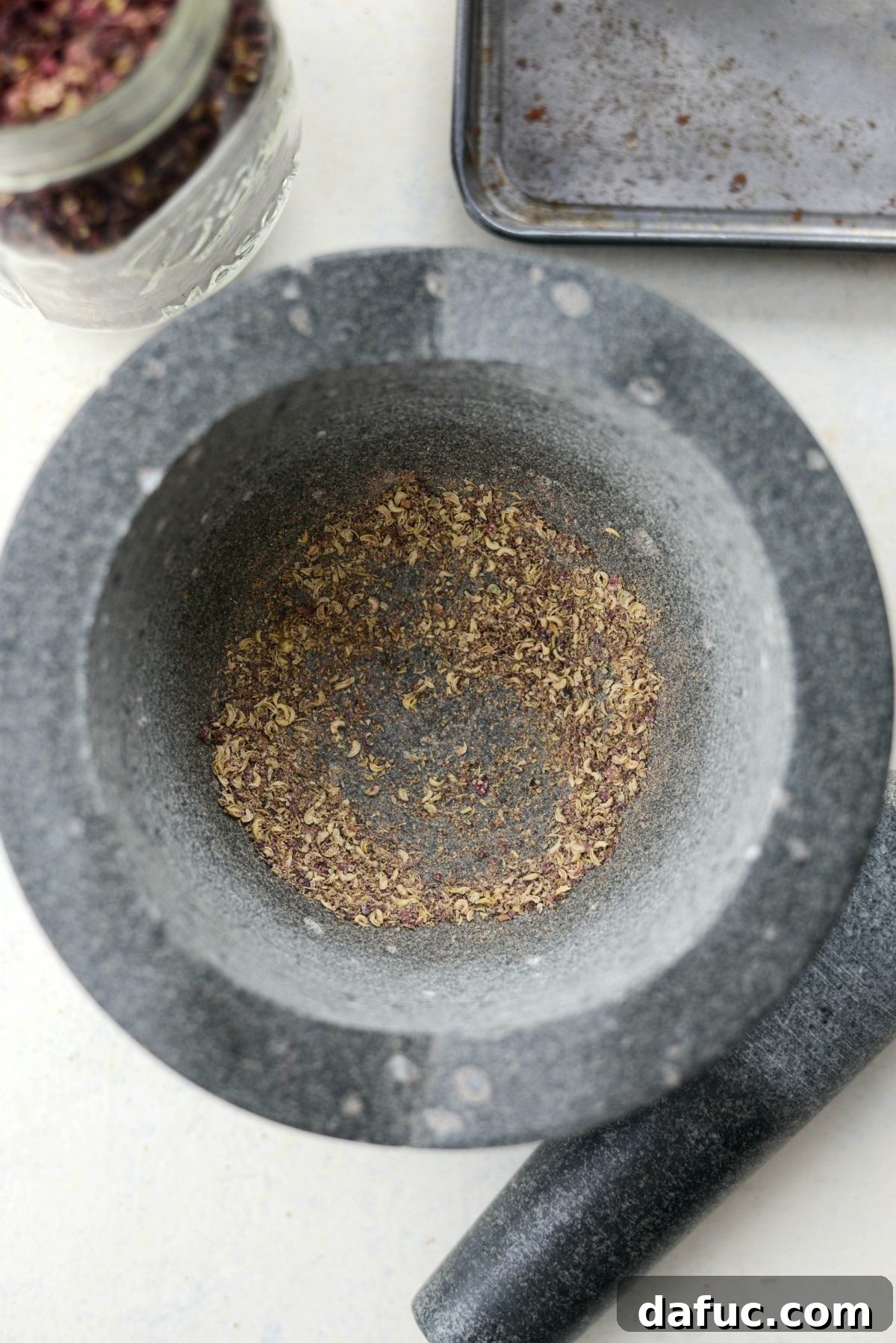 Grinding toasted hulls of Szechuan Peppercorns with a pestle