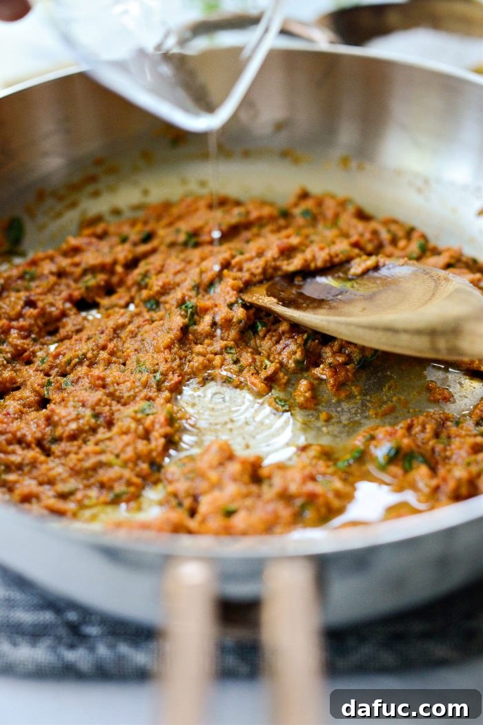 Golden Walnut & Sun-dried Tomato Pesto Pasta 12 Dry white wine being added to the sautéed pesto in the skillet, ready for deglazing