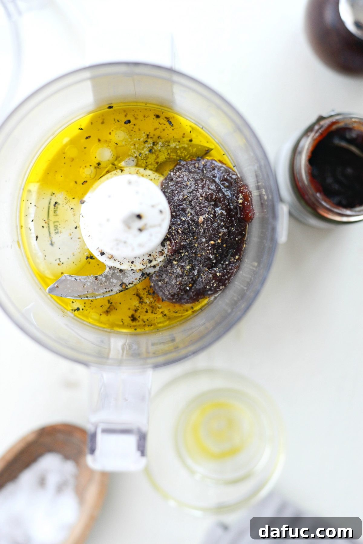 Adding ingredients for Pomegranate Jam Vinaigrette to a mini food processor