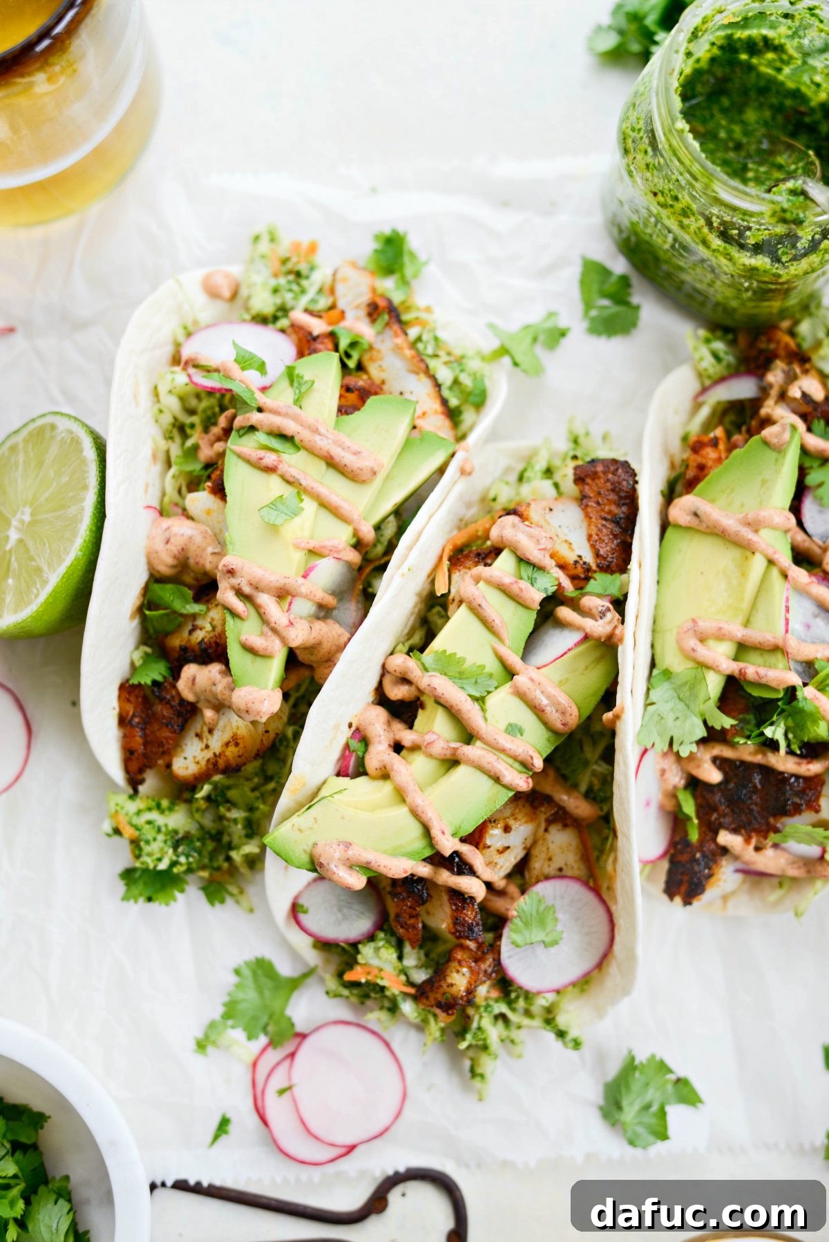 Delicious Blackened Fish Tacos piled high with toppings, served on a rustic wooden board.