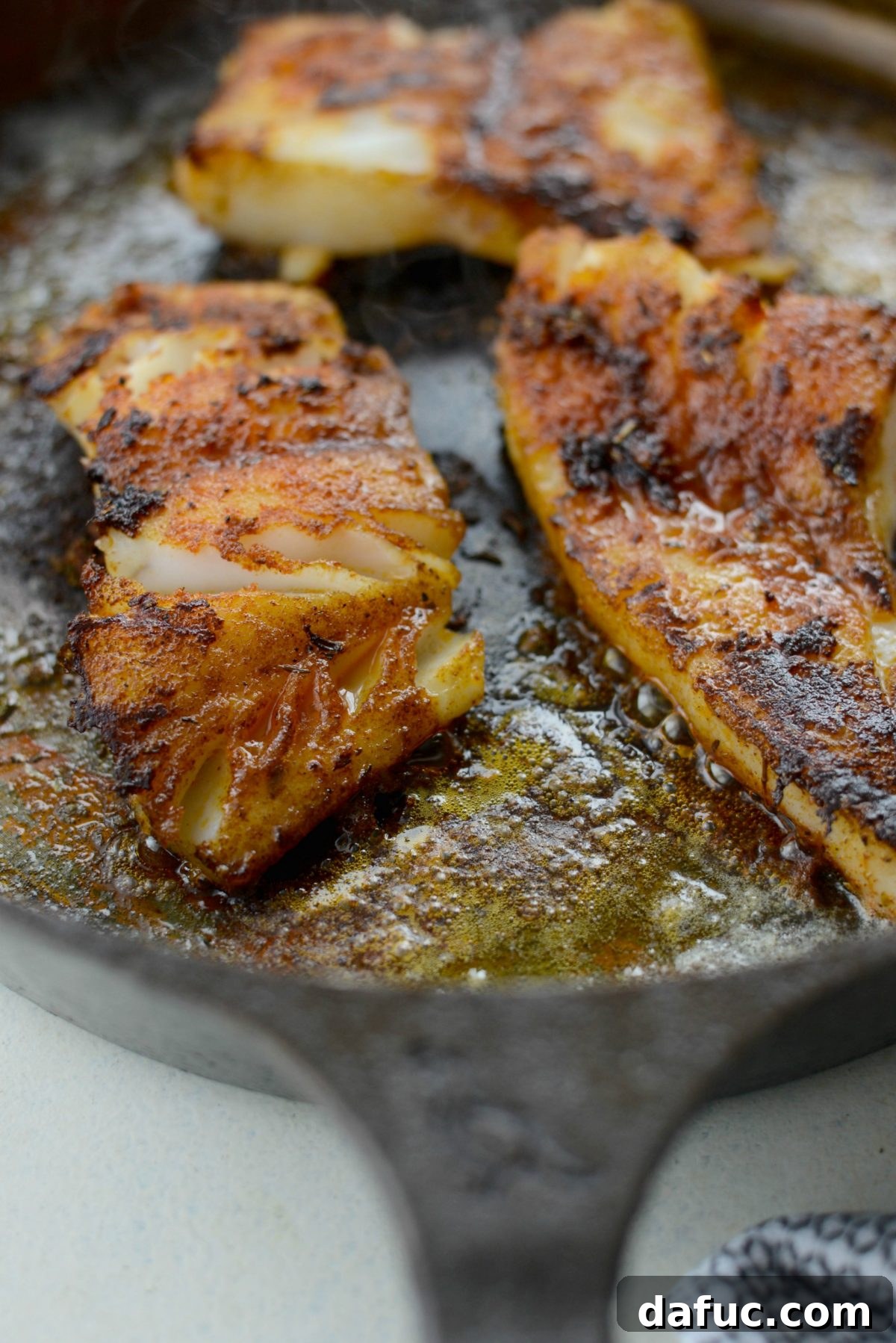 Perfectly cooked blackened fish in a cast iron skillet
