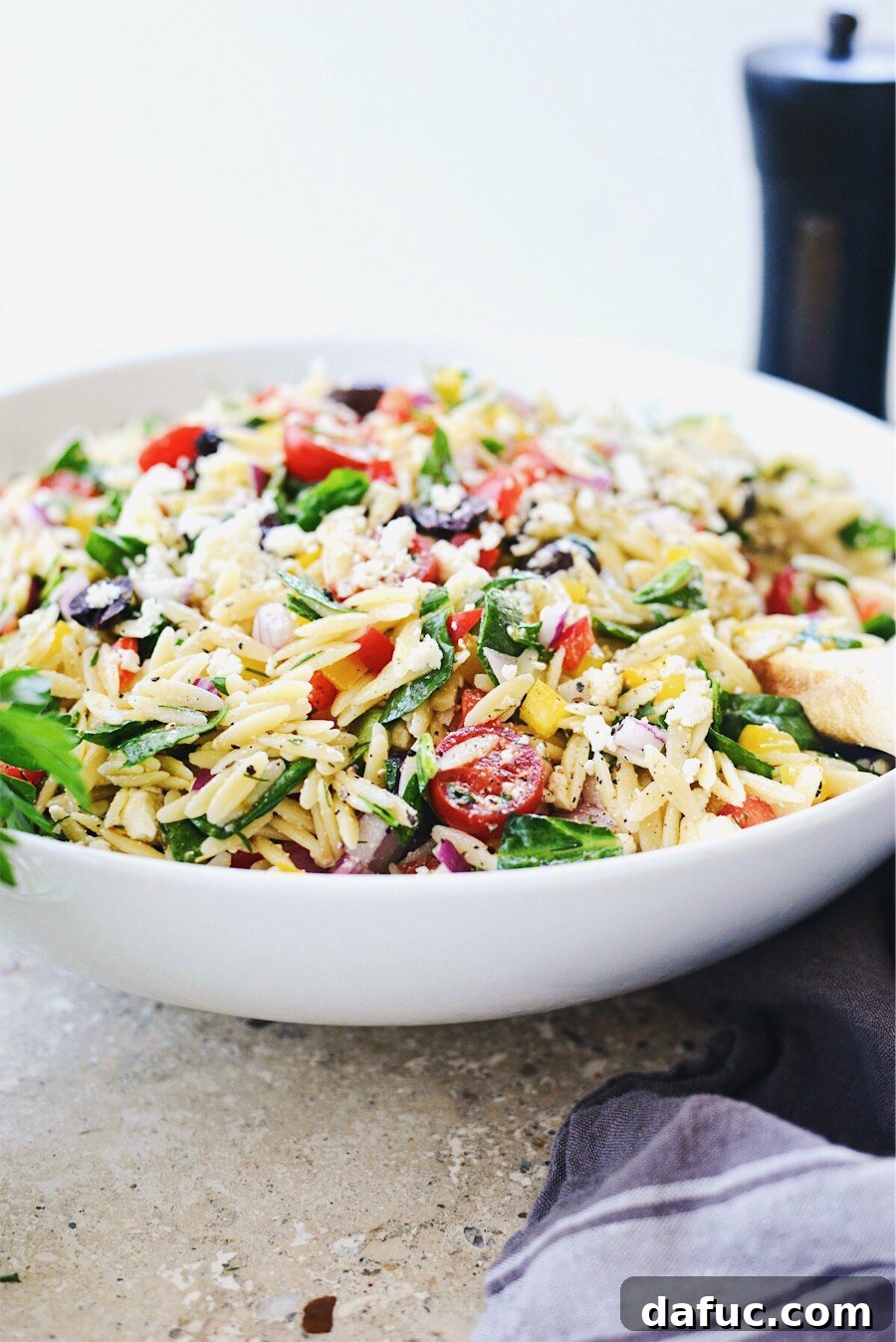 Vibrant Mediterranean Orzo Salad 3 Side view of Greek Orzo Salad in a white bowl, ready to serve