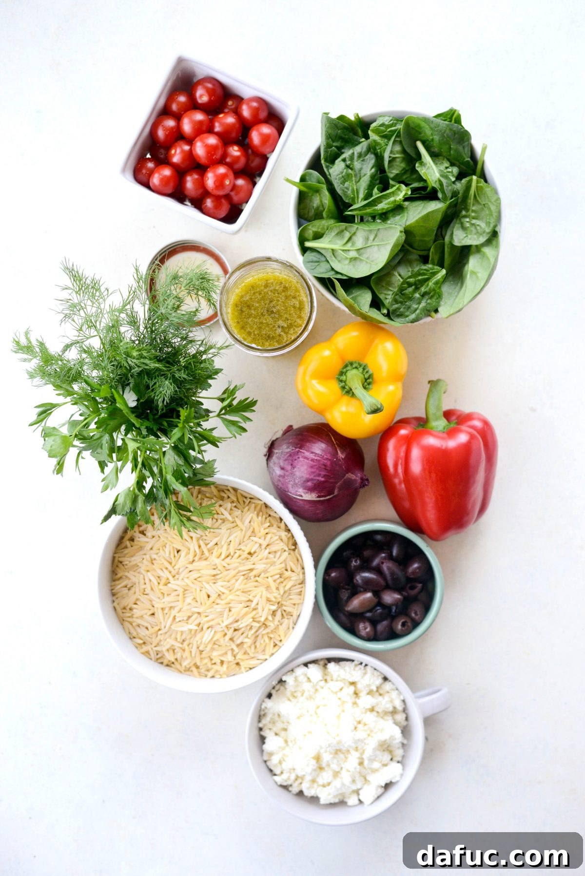 Vibrant Mediterranean Orzo Salad 4 Greek Orzo Salad Ingredients laid out on a wooden cutting board