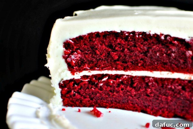 Timeless Red Velvet Cake 2 Inside a slice of Classic Red Velvet Cake revealing its moist, ruby red crumb and creamy white frosting.