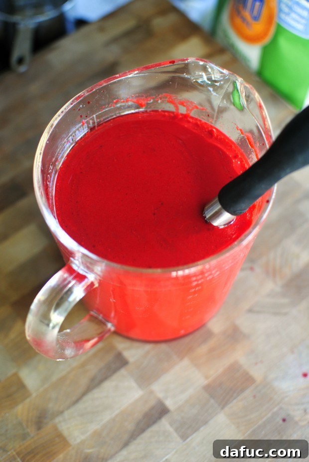 Timeless Red Velvet Cake 11 Whisking the wet ingredients together until fully combined and a vibrant red color is achieved for the Red Velvet Cake batter.