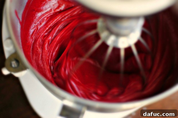 Timeless Red Velvet Cake 15 The Red Velvet Cake batter being mixed on medium speed until all ingredients are completely blended, resulting in a smooth, intensely red mixture.