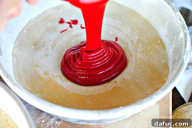 Timeless Red Velvet Cake 19 The smooth, red Red Velvet Cake batter neatly poured into the prepared cake pans, ready for baking.