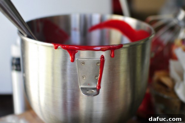 Timeless Red Velvet Cake 20 A finger taking a small swipe of the luscious Red Velvet Cake batter from the pan, a sweet moment before baking.