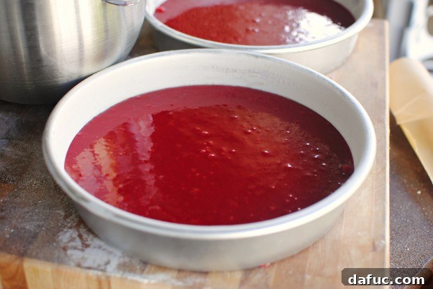 Timeless Red Velvet Cake 21 Gently tapping the cake pans on the counter to release any trapped air bubbles from the Red Velvet Cake batter before baking.