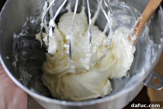 Timeless Red Velvet Cake 24 A bowl of freshly made, smooth, and tangy cream cheese frosting, the ideal accompaniment for a Classic Red Velvet Cake.