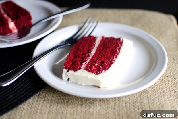 Timeless Red Velvet Cake 32 A perfect slice of Classic Red Velvet Cake, showing the moist red cake layers and generous cream cheese frosting, ready to be enjoyed.