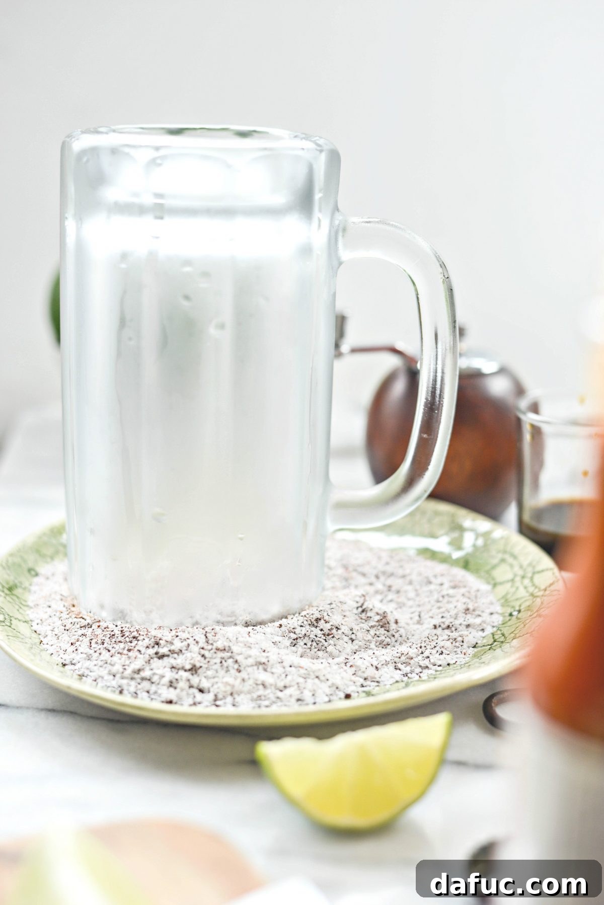 The Ultimate Mexican Michelada Recipe 9 Applying a lime wedge to the rim of a beer mug to prepare for salting