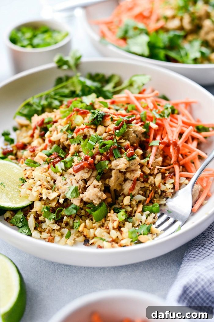 Overhead view of a delicious Quick Thai Chicken Cauliflower Rice Bowl garnished with cilantro
