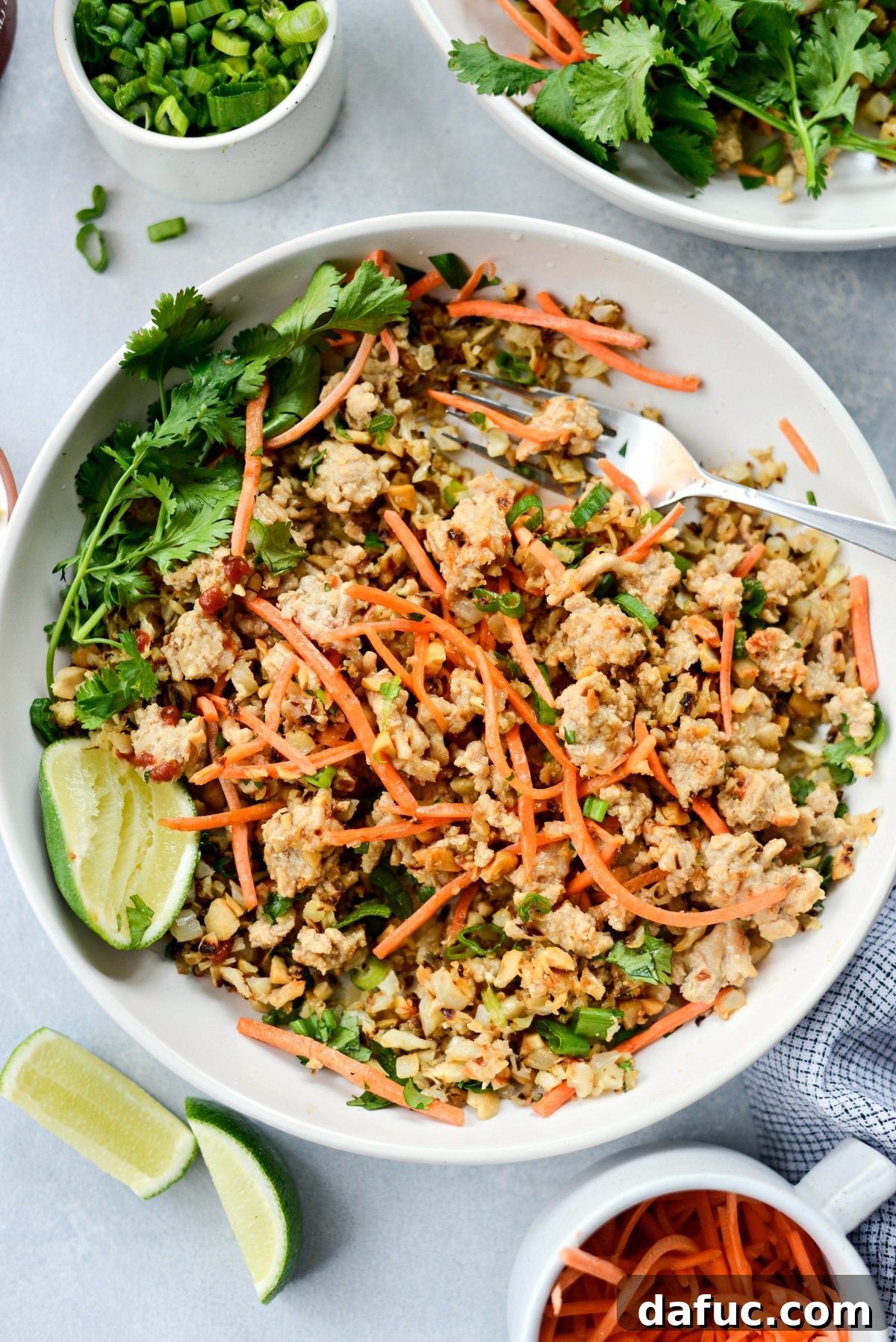 Final presentation of a delicious Thai Chicken Cauliflower Rice Bowl with fresh garnishes