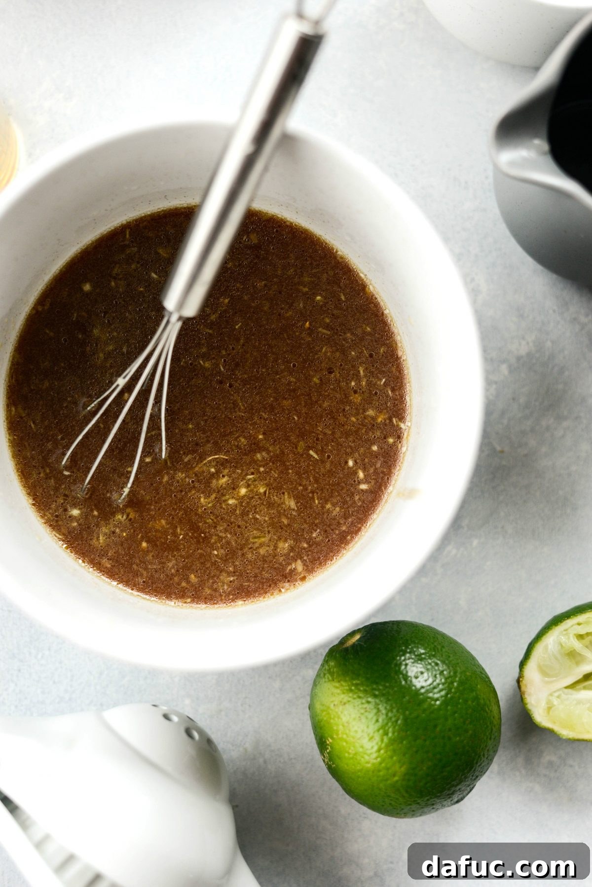 Mixing bowl with ingredients for Thai sauce, including lemongrass and lime