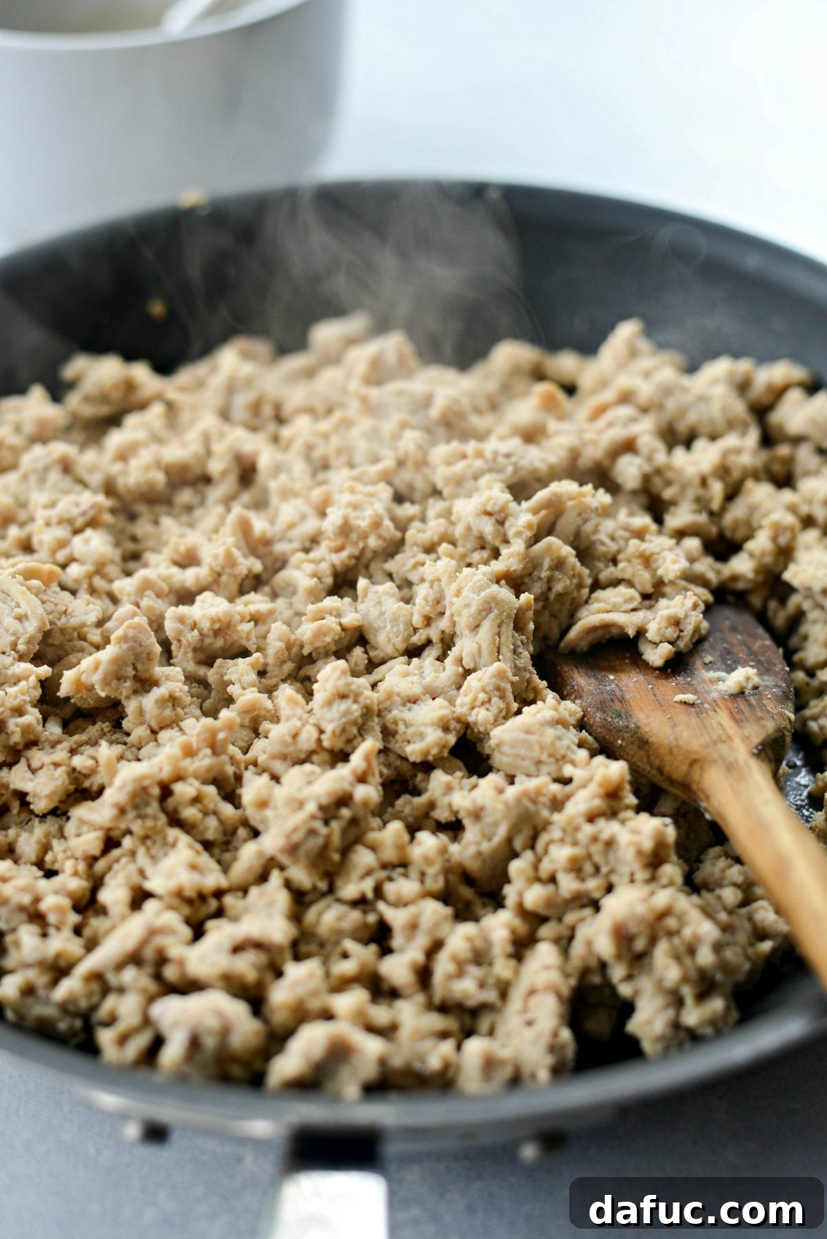 Perfectly cooked and crumbled lean ground chicken in a nonstick skillet
