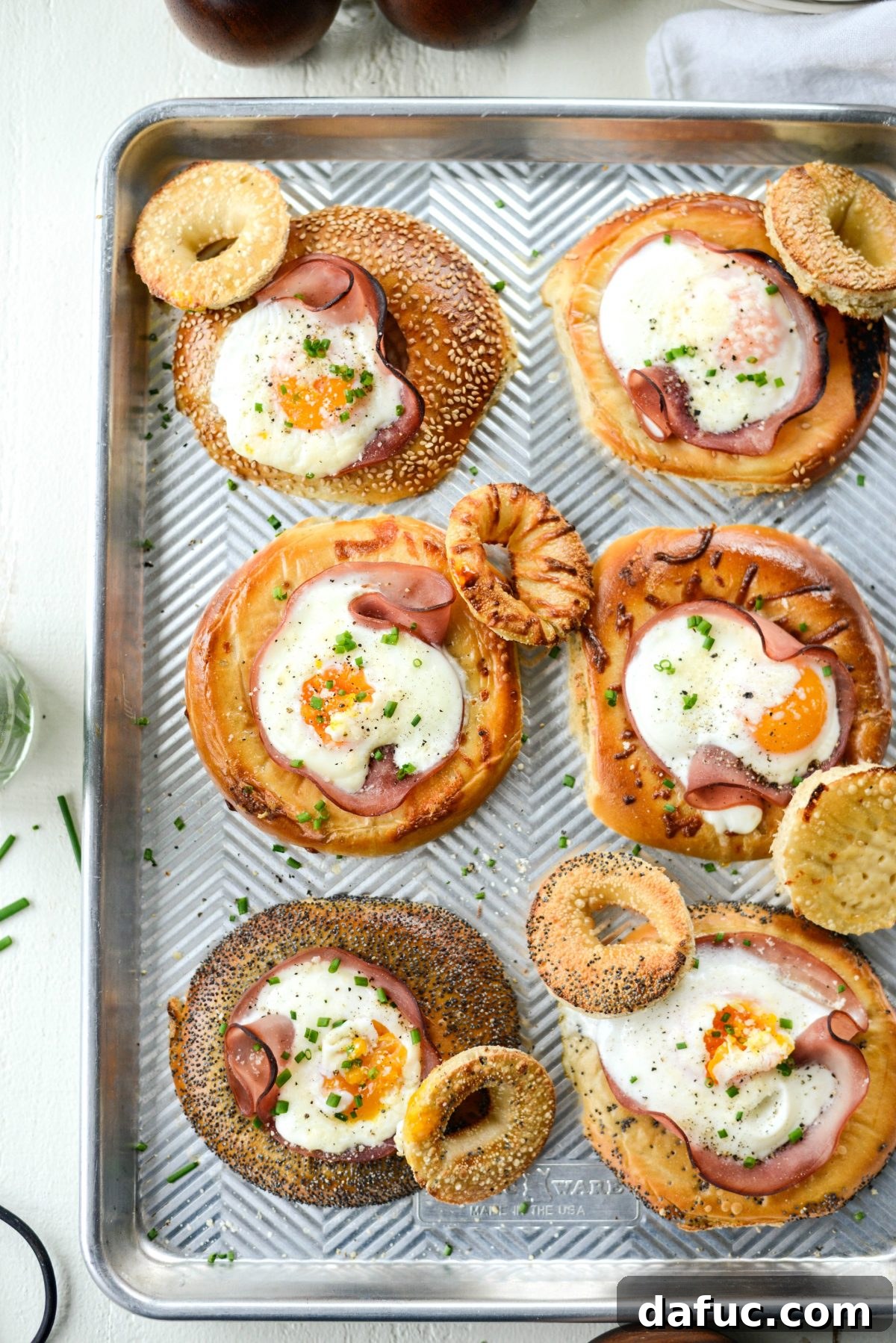 Bagel Egg Nests 2 Baked Egg in a Hole Bagels with ham, eggs, and chives, served on a sheet pan