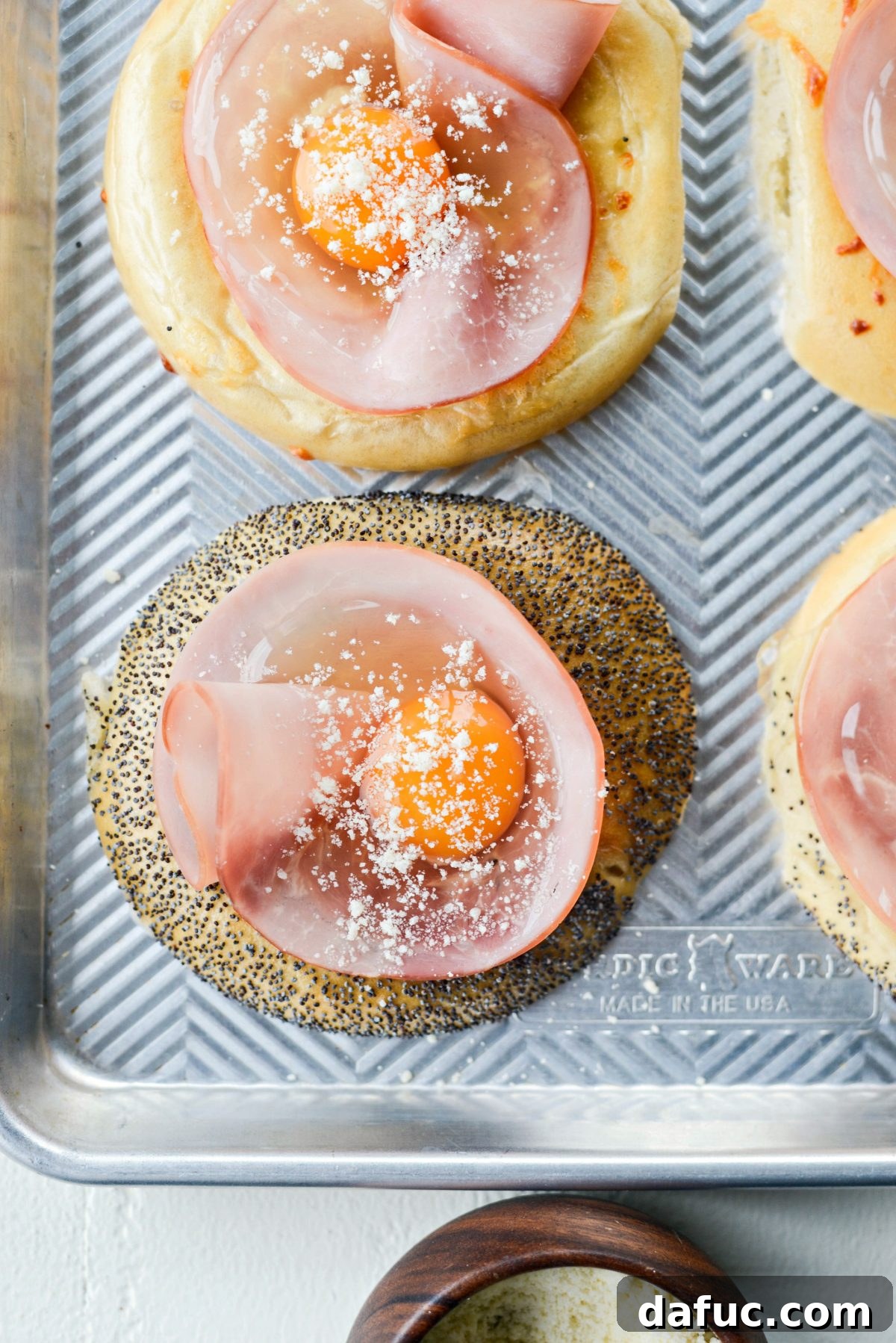 Bagel Egg Nests 12 Parmesan cheese being sprinkled over eggs in bagels