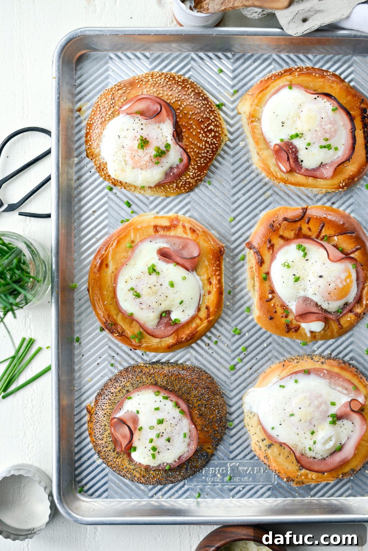 Bagel Egg Nests 14 Baked Egg in a Hole Bagels on a serving tray, garnished with chives