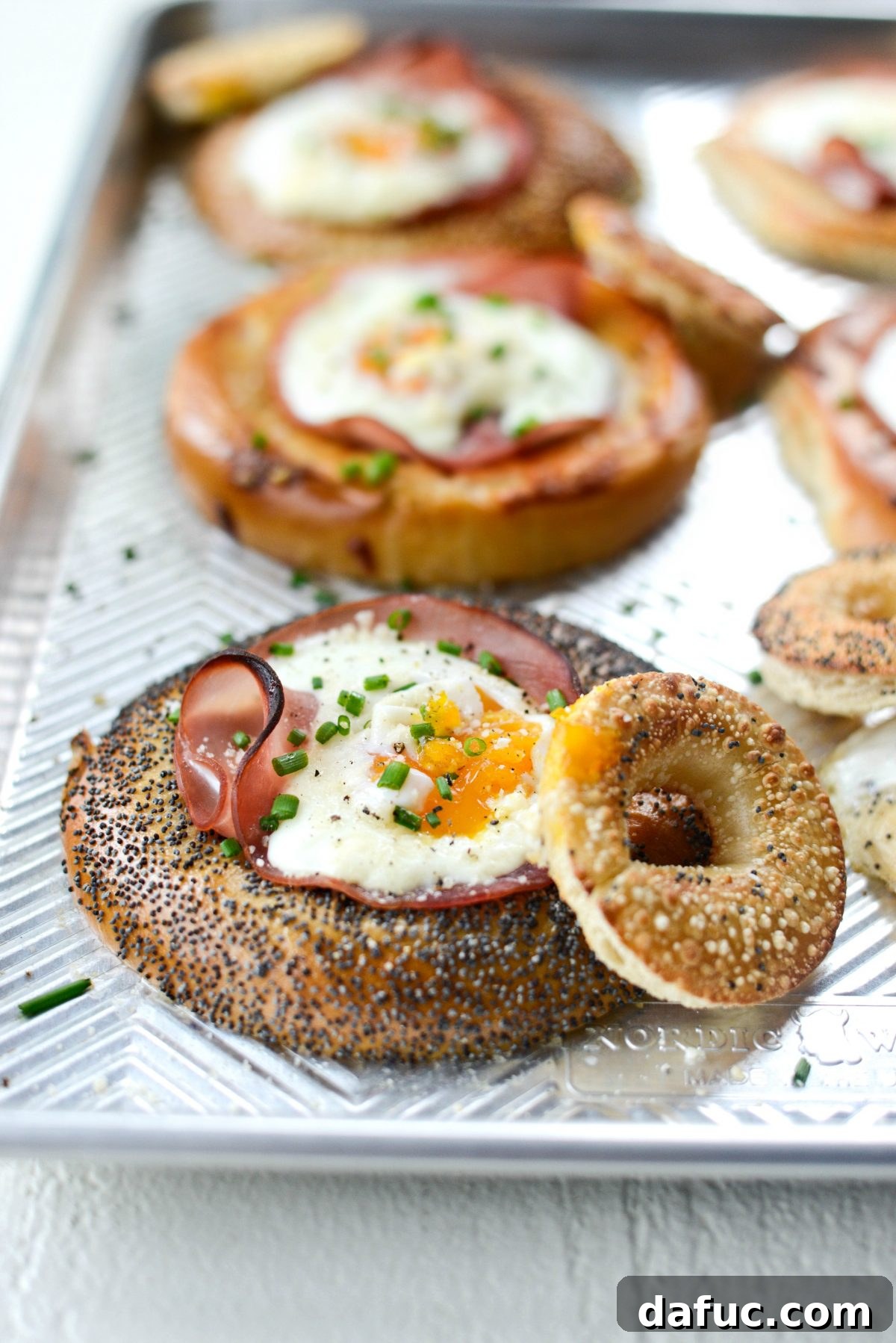 Bagel Egg Nests 3 Two baked egg in a hole bagels on a white sheet pan