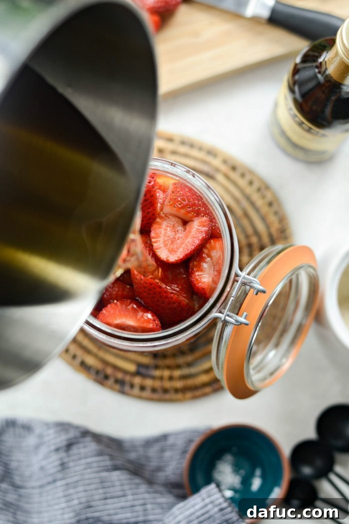 Vinegar-Kissed Strawberries 10 Pouring warm pickling liquid over strawberries in a jar.