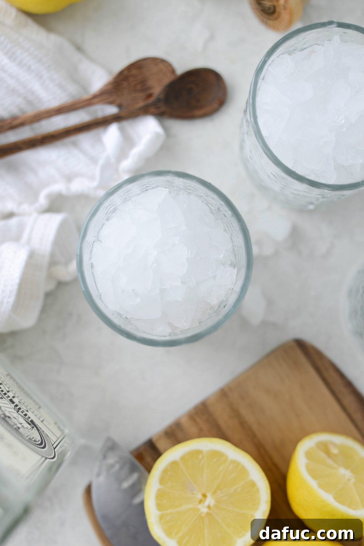 Two glasses filled to the brim with ice, ready for mixing Lemon Gin Fizz
