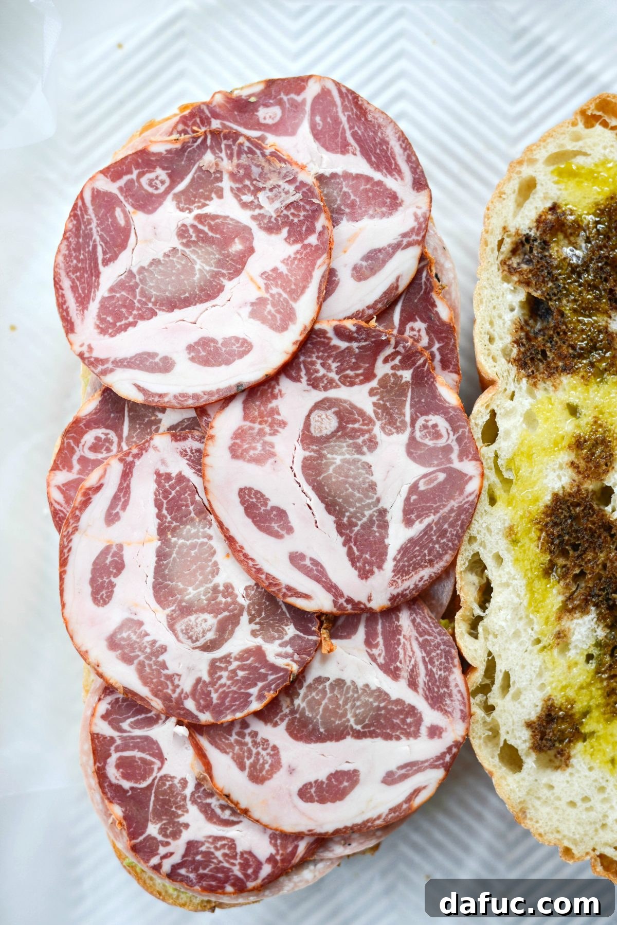 Pressed Italian Perfection 9 Layer capocollo slices on top of the salami.