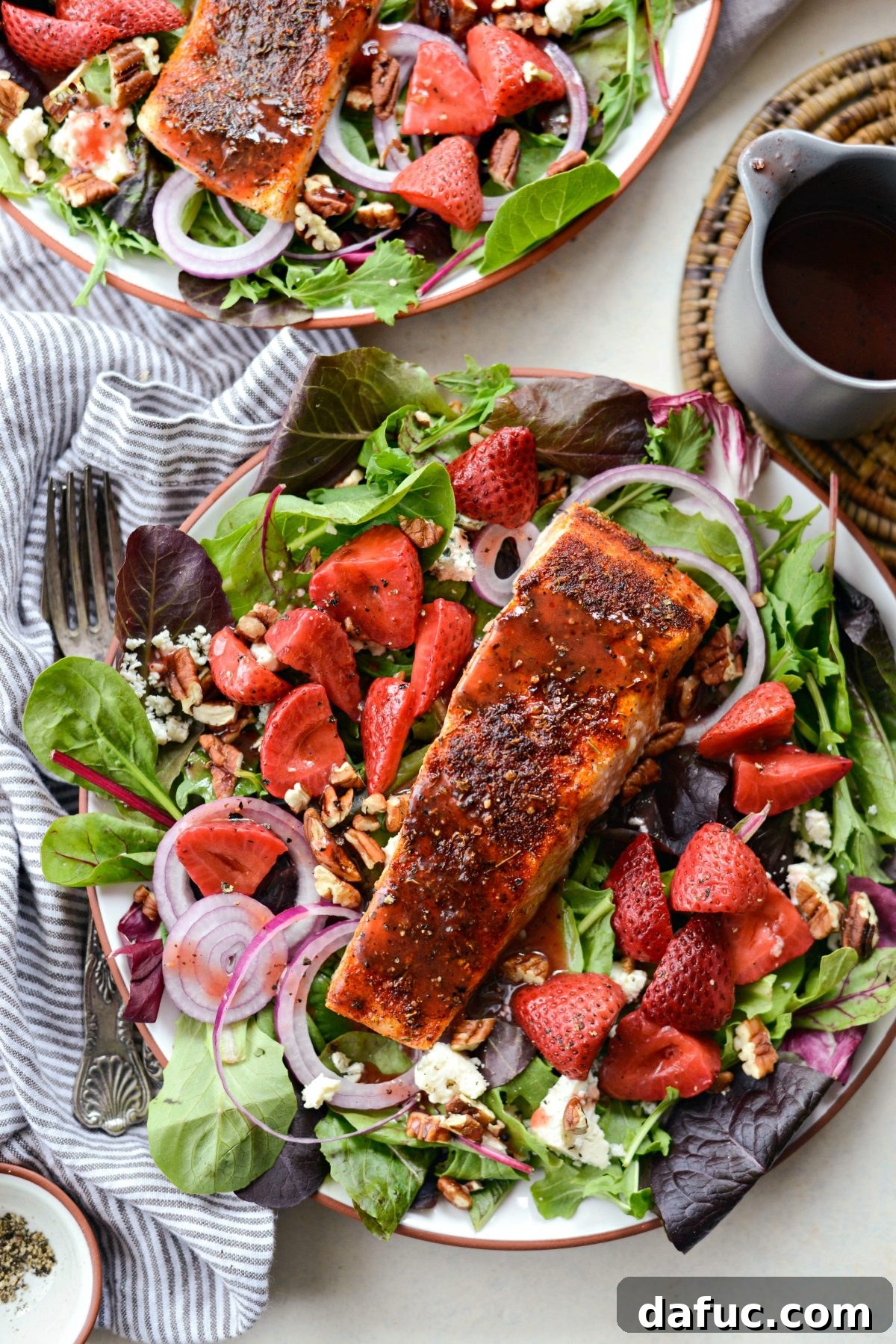 Blackened Salmon Salad with vibrant spring greens, perfectly baked salmon, and a sweet-tangy strawberry peppercorn vinaigrette.