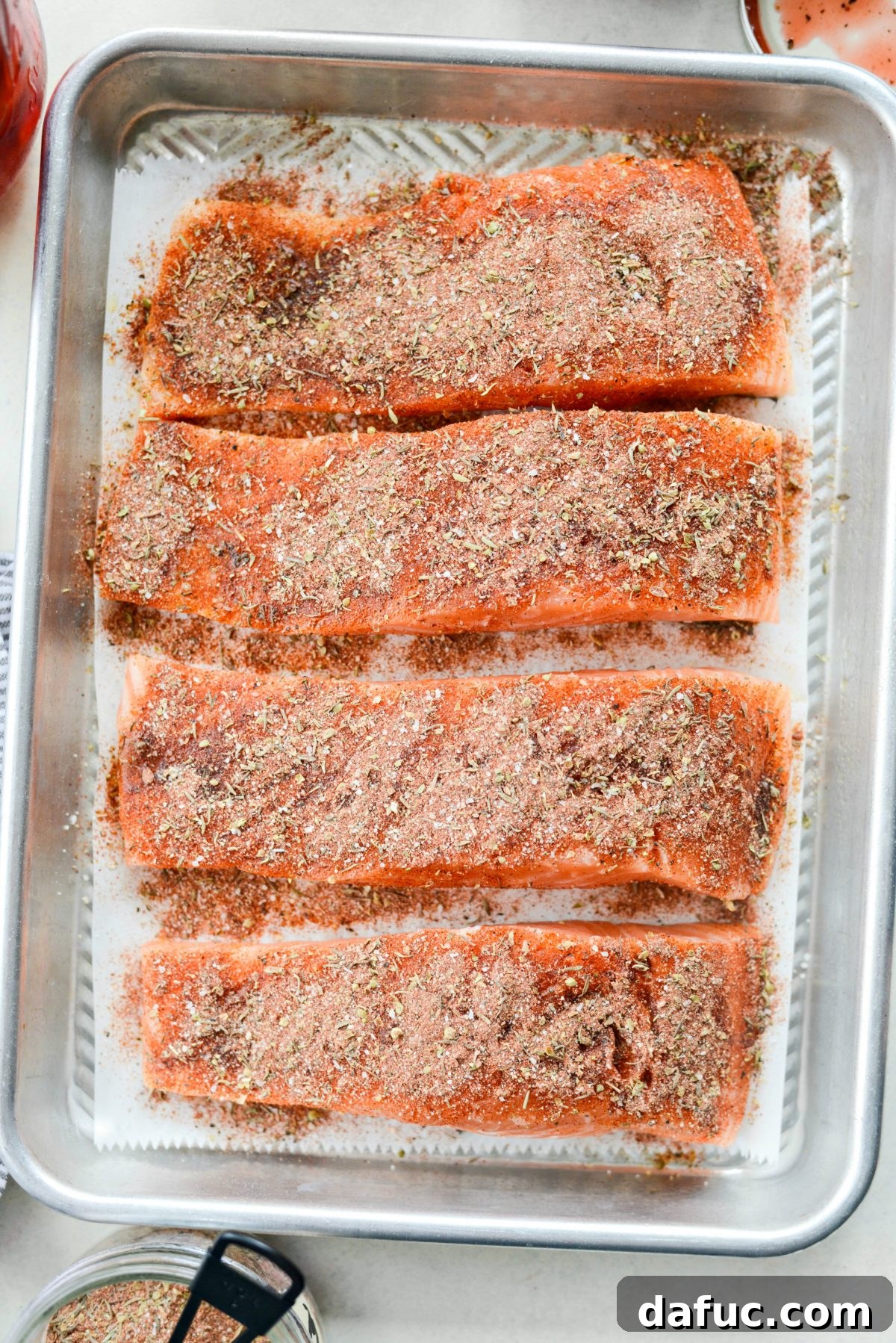 Close-up of blackened seasoning liberally applied to a salmon fillet before baking.