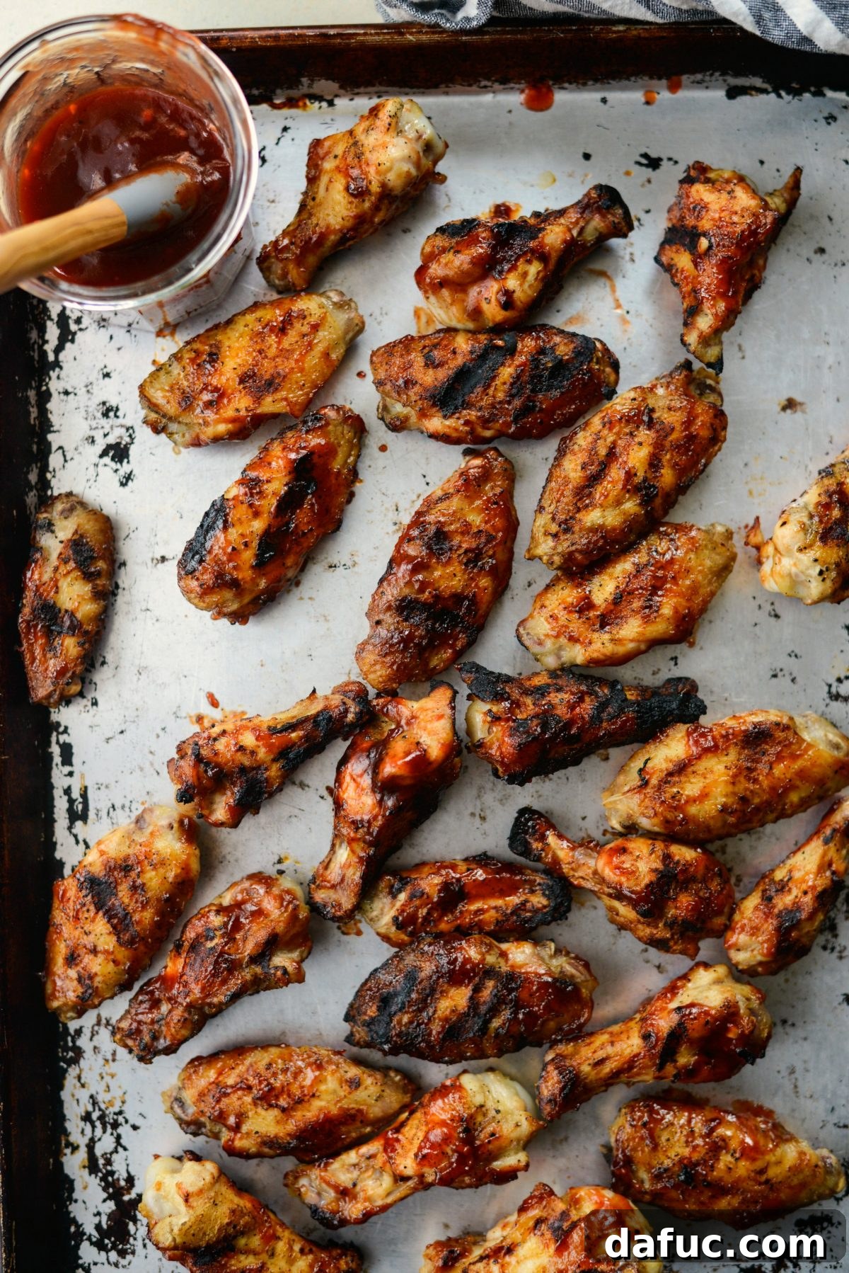 Sweet & Smoky Cherry Chipotle Wings 17 Transferring cooked grilled chicken wings to a rimmed sheet pan
