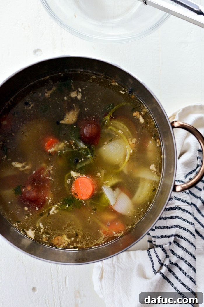 Congealed chicken cooking liquids melting into the hot soup pot