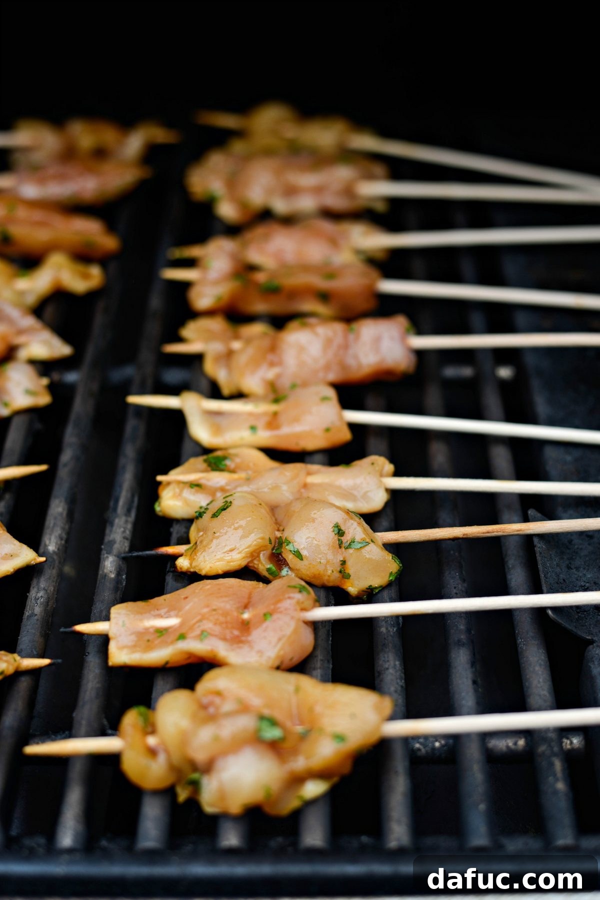 Thai Chicken Satay Skewers with Creamy Peanut Sauce 13 Chicken satay skewers grilling on an outdoor barbecue