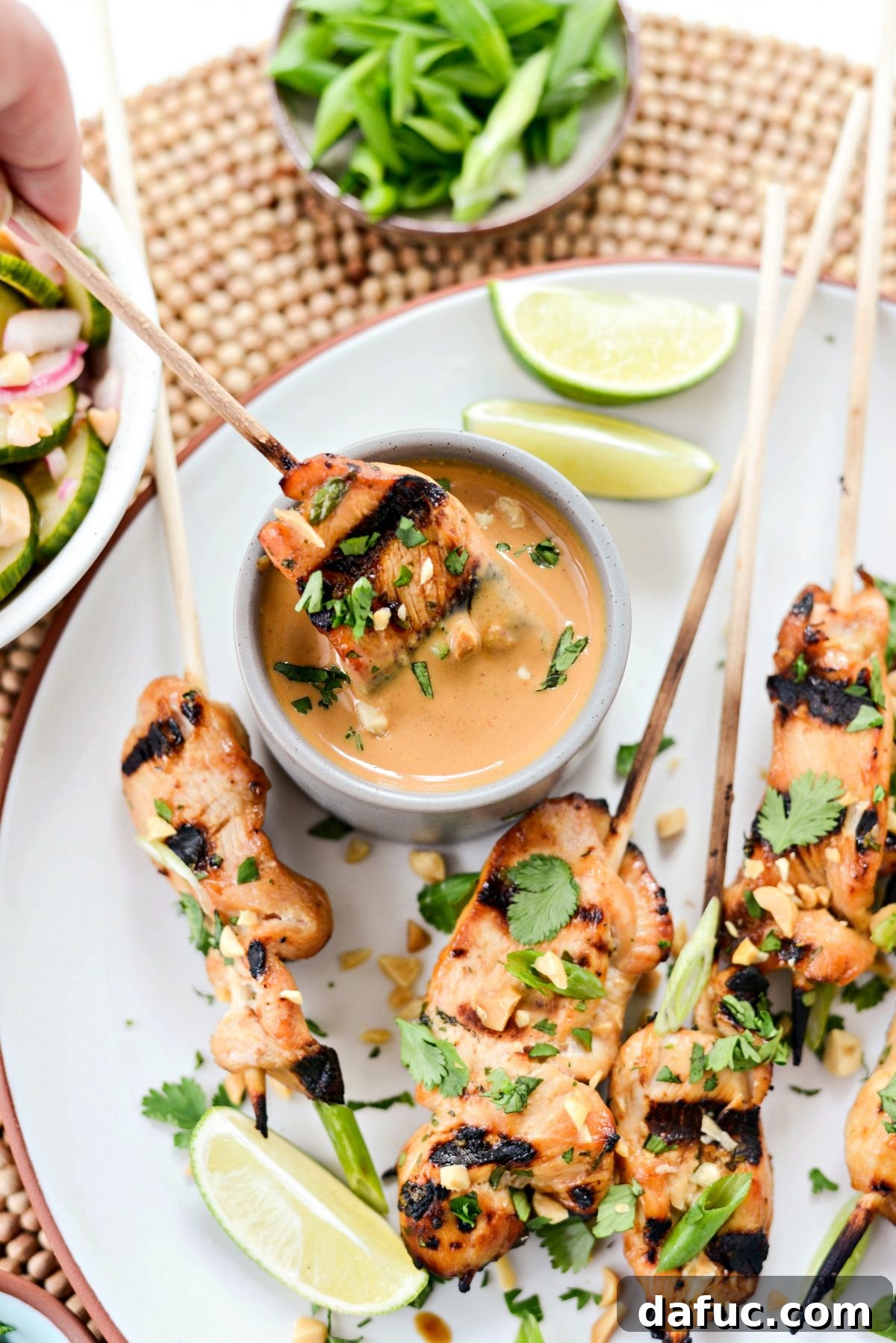 Thai Chicken Satay Skewers with Creamy Peanut Sauce 18 Chicken Satay skewer being dipped into a bowl of Thai Peanut Sauce