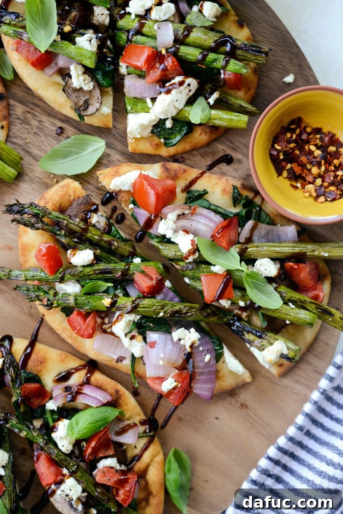 Close-up of Vegetable and Goat Cheese Flatbread with balsamic glaze and basil.