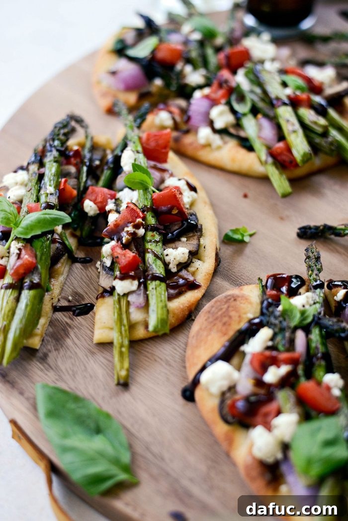 Homemade Vegetable and Goat Cheese Flatbread on a wooden cutting board.