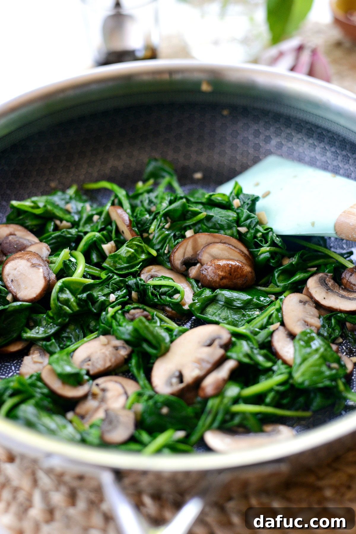 Mushrooms and garlic being sautéed in a pan.