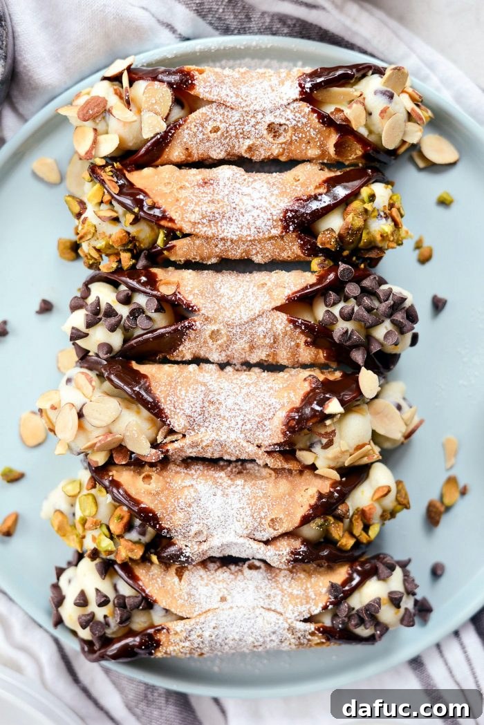 Easy Homemade Cannolis - Crisp shells filled with sweet ricotta, dipped in chocolate and nuts.