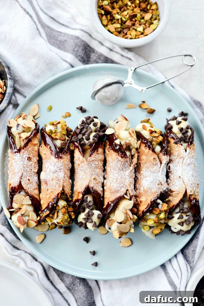 Easy Homemade Cannolis garnished with chocolate chips and pistachios.
