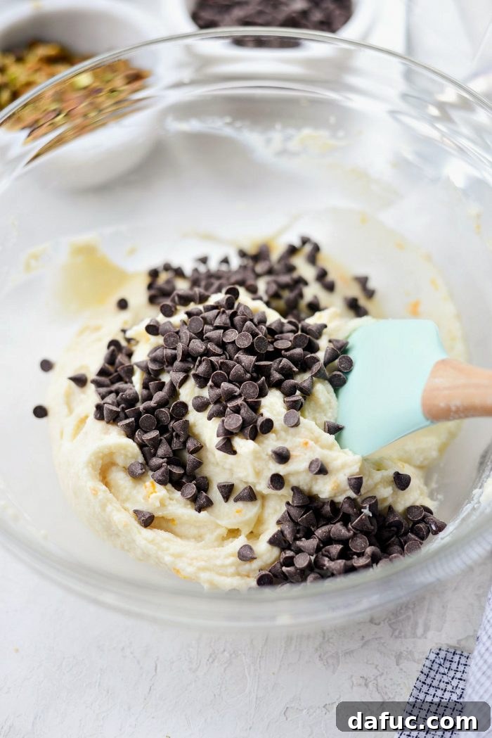 Folding mini chocolate chips into ricotta cannoli filling.
