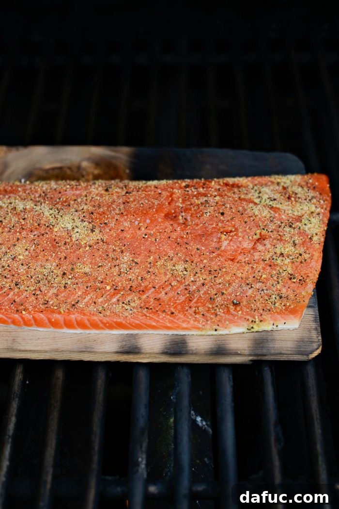 Signature Grilled Whiskey Glazed Cedar Plank Salmon 12 Salmon fillet being seasoned generously with lemon pepper