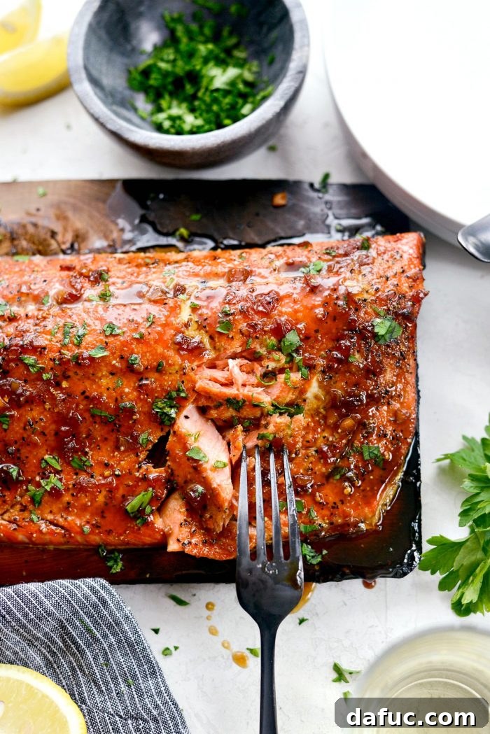 Signature Grilled Whiskey Glazed Cedar Plank Salmon 18 Plated grilled whiskey glazed cedar plank salmon with lemon and parsley garnish