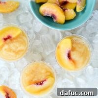 Peach Frosé served in a glass with a peach slice garnish.
