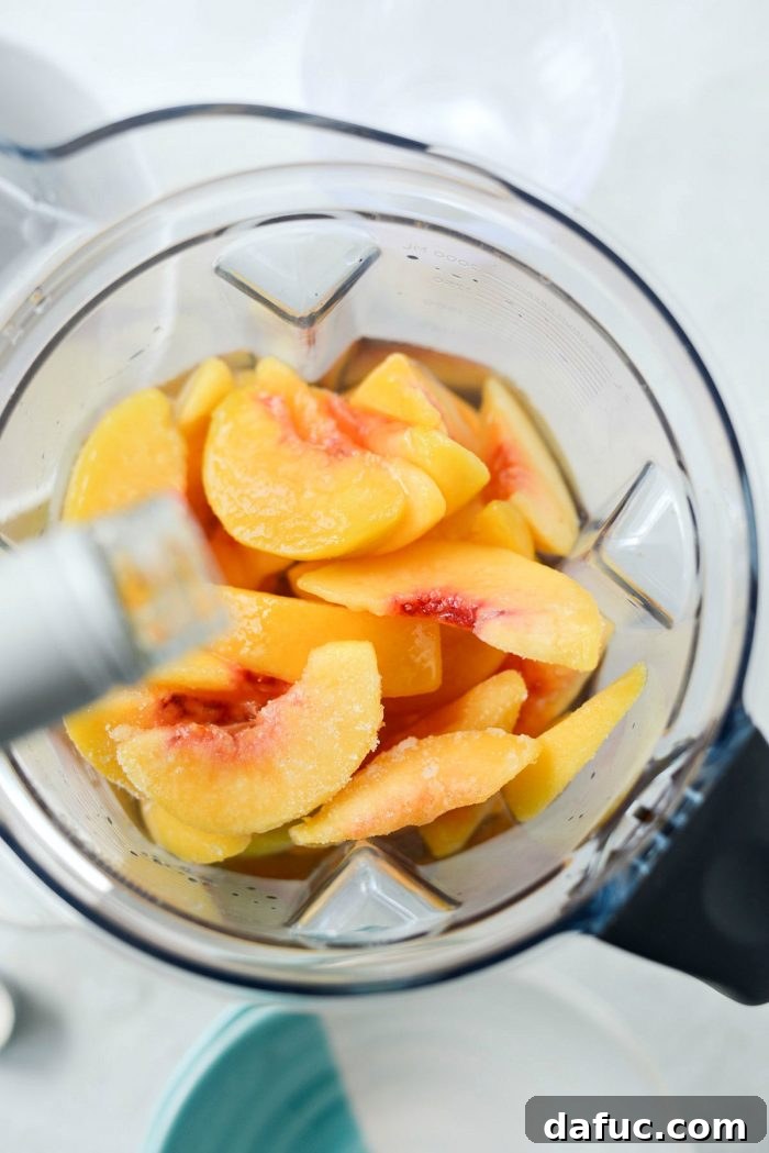 Blushing Peach Dream 8 Pouring rosé wine into the blender with peaches and ice.